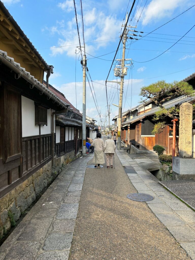 Local residents walking along a quiet traditional street in Takatori castle town