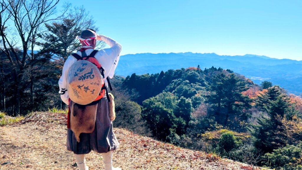 Yamabushi practicando entrenamiento espiritual shugendō con vistas a las montañas sagradas de Yoshino